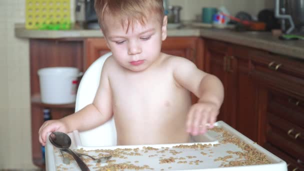 Menino brincando com ervilhas e feijão — Vídeo de Stock