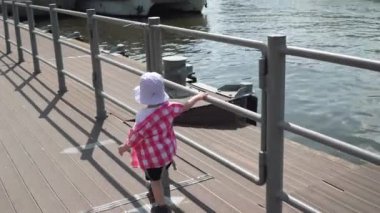 İskelede Panama şapkalı bir çocuk.