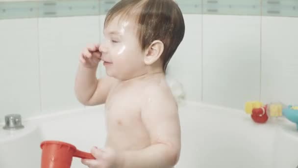 Bébé garçon dans la salle de bain boissons — Video