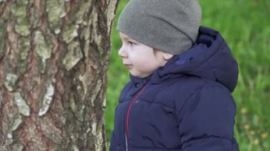 Çocuk ağaca dokunur.