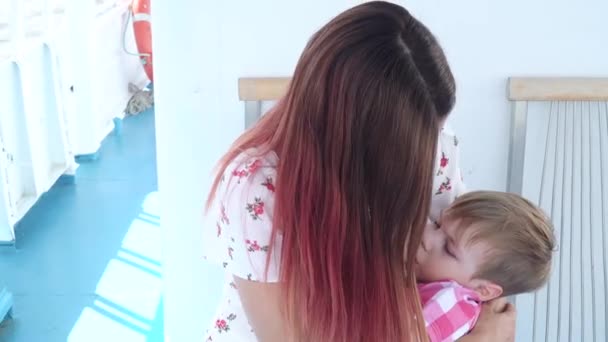 Mam geeft haar zoon borstvoeding aan boord. — Stockvideo