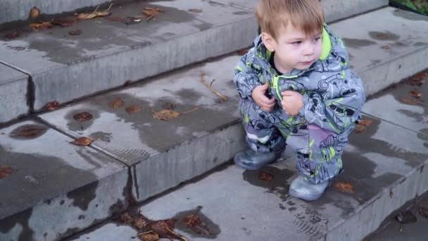 Мальчик на корточках на лестнице — стоковое видео