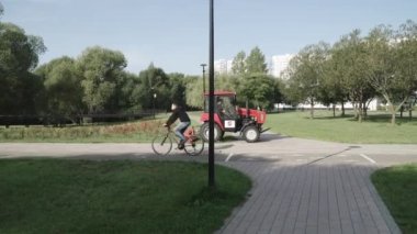 Şehir parkında traktör çim biçme makinesi.