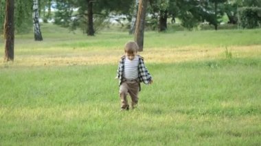 Bir çocuk çimenlerde yürüyor