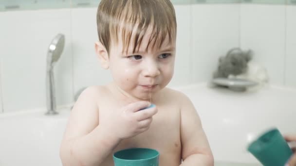 Baby jongen in de badkamer drankjes — Stockvideo