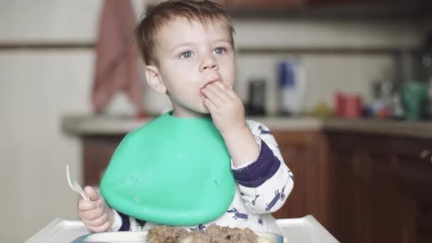 Хлопчик їсть курячу печінку і серце — стокове відео
