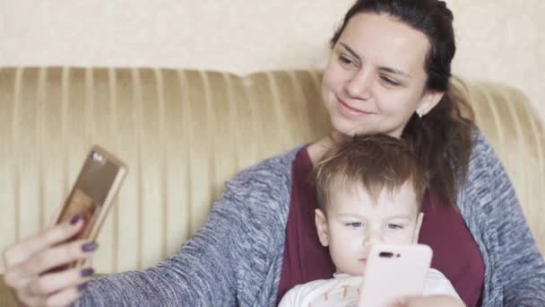 Pojke med mamma på soffan — Stockvideo