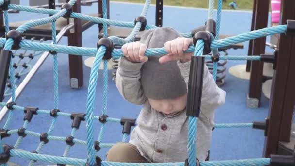 En pojke går på en lekplats — Stockvideo