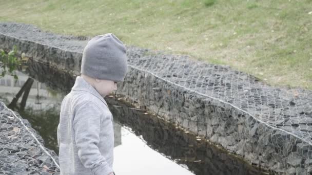 Мальчик на берегу реки — стоковое видео