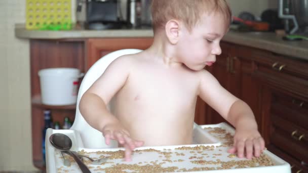 Хлопчик грає з горохом і квасолею — стокове відео
