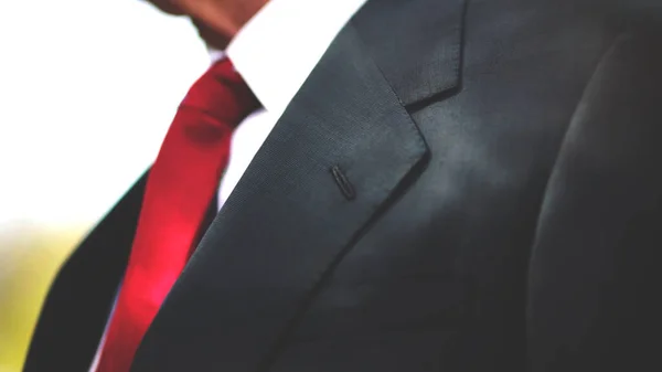 Beyaz gömlekli, kırmızı kravatlı siyah bir iş ceketi, erkek boyun ve göğsü fotokopi arkaplanı ile yakın plan.