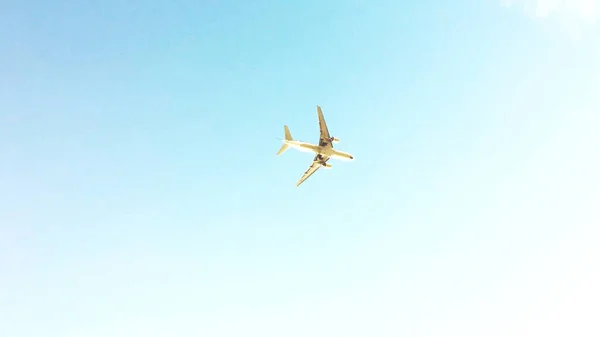 Mavi gökyüzünde bir uçak, uçan bir uçağın altında. Düşük açılı çekim arkaplanı kopyalama alanı.