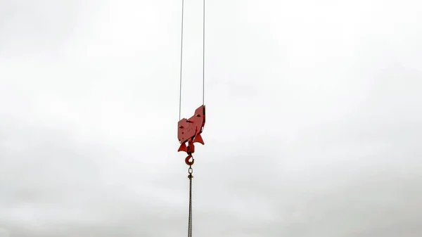 Turna kırmızısı beyaz bulutlu gökyüzüne karşı kaldırma kancası. endüstriyel arkaplan.