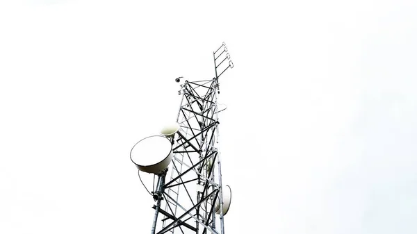 Düşük açılı bulutlu gökyüzüne karşı radyo anten kulesi telekomünikasyonu. Beyaz arkaplanda izole.