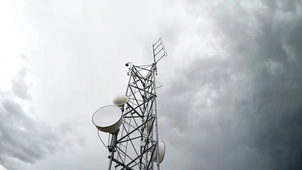 Düşük açılı bulutlu beyaz gökyüzüne karşı radyo anten kulesi telekomünikasyonu. İzole edilmiş arkaplan.