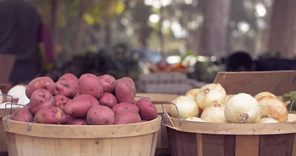 Marketteki tahta kovada kırmızı patates ve beyaz soğan. Taze sebzeler açık hava pazarı geçmişi.