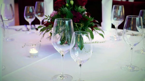 wine glasses on a decorated wedding table with bouquet flowers, wedding reception concept background.