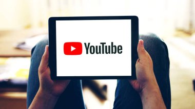 New York, ABD - 28 Şubat 2020: Tablet ekranda Youtube uygulaması logosu, evde online video izleyen bir kişinin eline seçici odaklanma.