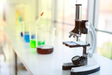 Tablo için labolatory caymak Oda renkli şişeler arka planda elektron mikroskobunun.