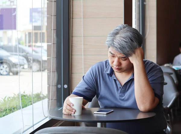 Yorgun genç Asya Orta yaşlı adam, yaşlı adam almak el baş duygu depresyon üzerinde vurguladı ve yorgun pencerenin coffee shop, gri saçlı adam oturuyor, aile sorunları.