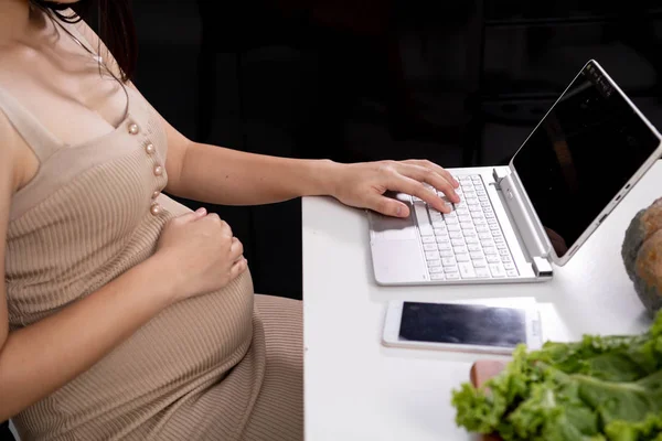 Las mujeres embarazadas están usando computadoras portátiles para el uso de Internet. Buscar médico — Foto de Stock