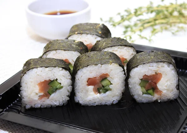 Delicious fresh sushi with sheets of lettuce on white background — Stock Photo, Image
