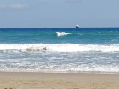 Plaj ve berrak gökyüzü karşı ufukta gemi