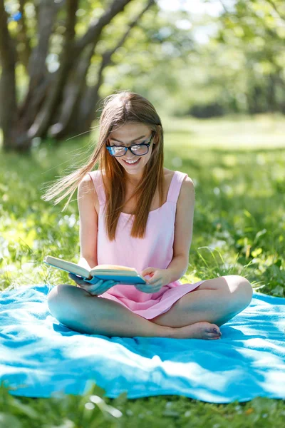 屋外の本を読んで 美しい若い白人の女性の肖像画 草の上に座ってください — ストック写真