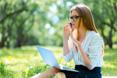 Öğle yemeği molası Şehir Parkı içinde dizüstü kullanarak iş kadını 