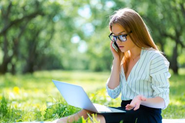Öğle yemeği molası Şehir Parkı içinde dizüstü kullanarak iş kadını 