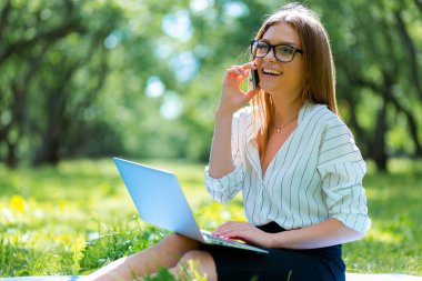 Öğle yemeği molası Şehir Parkı içinde dizüstü kullanarak iş kadını 