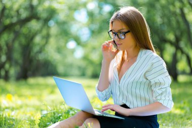 Öğle yemeği molası Şehir Parkı içinde dizüstü kullanarak iş kadını 