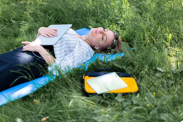 Frau Liegt Mit Laptop Park Und Hört Musik — Stockfoto