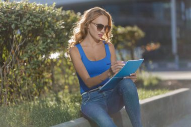 Sokakta elinde bir defter tutan genç ve güzel bir kadın. İş ya da eğitim yaşam tarzı kavramı