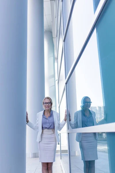 Stressed business woman standing next to the wall of an office building