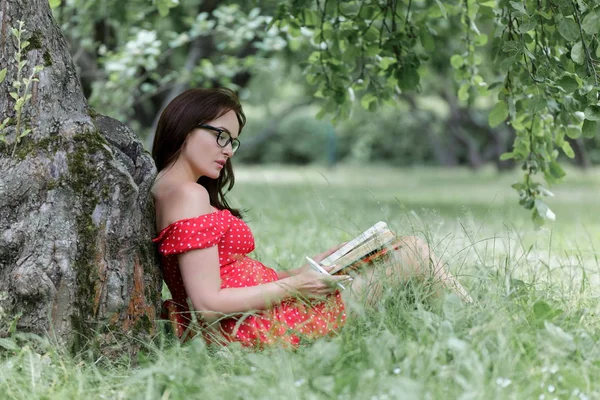 Jonge Vrouw Zittend Het Gras Onder Boom Leest Een Boek — Stockfoto
