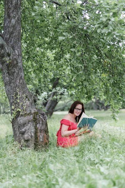 Jonge Vrouw Zittend Het Gras Onder Boom Leest Een Boek — Stockfoto