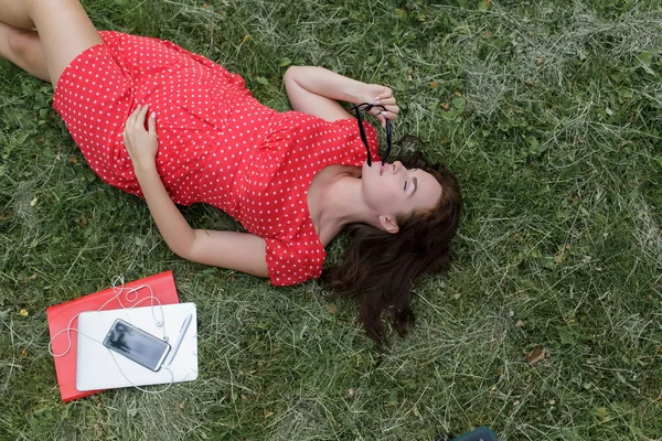 Schöne Frau Die Auf Dem Gras Liegt Umgeben Von Geräten — Stockfoto