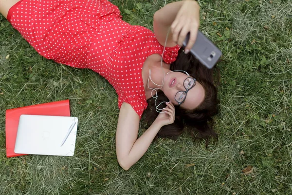 Mulher Bonita Leva Selfie Deitado Grama Cercou Seus Papéis Vista — Fotografia de Stock