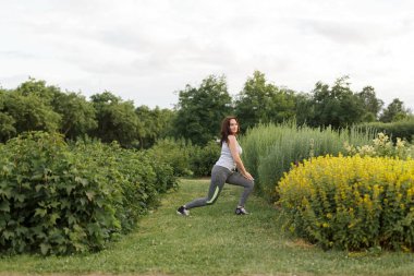 Genç mutlu sportif kız egzersiz Şehir Parkı koşu sonra germe