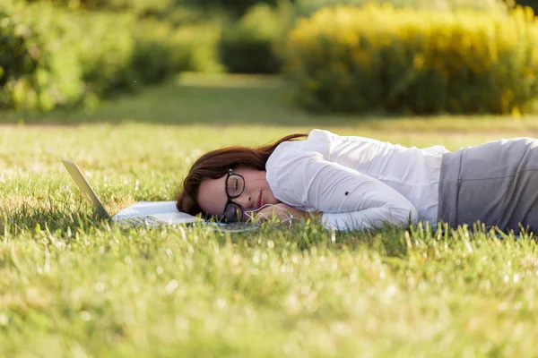 Menina Negócios Deitada Uma Grama Verde Dormindo Lado Seu Laptop — Fotografia de Stock