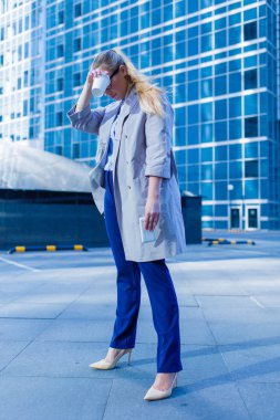 Yalnızlık iş kadını ile fincan kahve ve smartphone ayakta şehir arasında