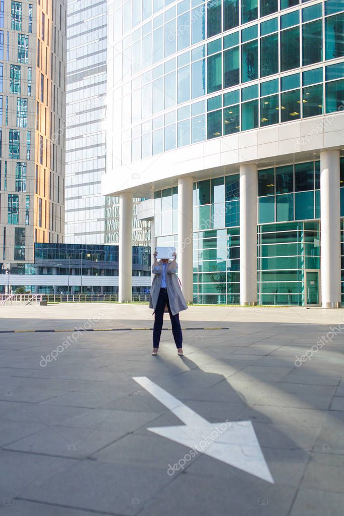 Loneliness business woman with cup of coffee and smartphone standing among the downtown
