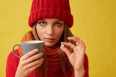 Hap ve elleri bir kaba tutan hasta kadın. Sarı arka plan görüntü.