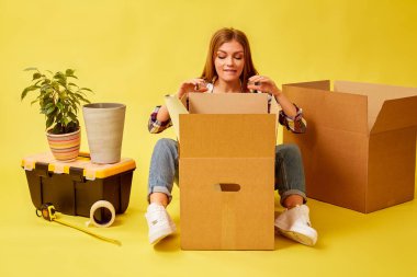 Hareketli Kutular ortasında oturan kadın. Yeni p hareket insanlar