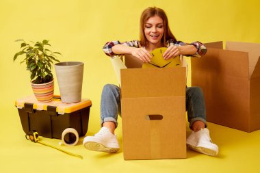 Hareketli Kutular ortasında oturan kadın. Yeni p hareket insanlar