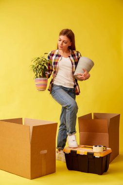 Genç bir kadın bir çiçek ve bir pot ile onun elleri betwee durumda