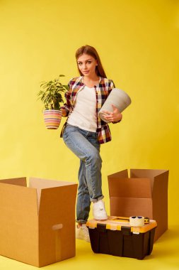 Genç bir kadın bir çiçek ve bir pot ile onun elleri betwee durumda