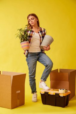 Genç bir kadın bir çiçek ve bir pot ile onun elleri betwee durumda