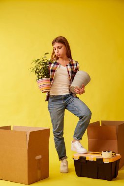 Genç bir kadın bir çiçek ve bir pot ile onun elleri betwee durumda